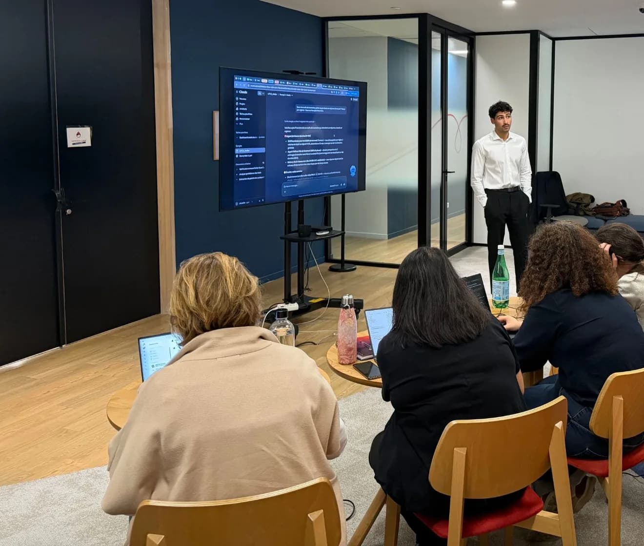 Tandem trainer in front of a screen showing Claude, participants practicing on their workstations